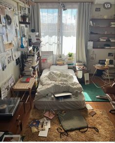 a messy bedroom with lots of clutter on the floor and bookshelves all around