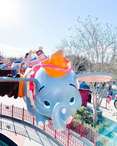 an elephant ride at a carnival with people riding on the top and one in the middle