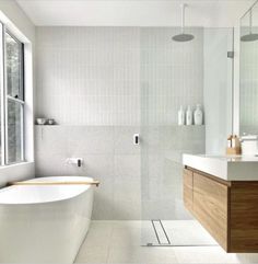 a bathroom with a tub, sink and large window