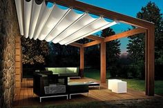 an outdoor living area with couches and tables under a pergolated awning