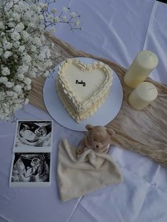 a heart shaped cake sitting on top of a table next to a vase with flowers