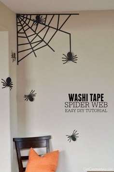 the wall is decorated with black spider webs and orange pillows for halloween decorating