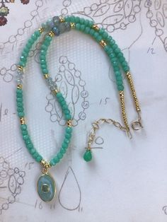 This gemstone beaded choker/necklace has shades of aqua and gold metal bead accents. It has an inlaid bezel oval aventurine pendant. It has gold metal tube bead accents with a gold filled ring clasp and extender chain. It is 15" long with a 2" extender which makes it adjust to 17" long. Aqua Gemstone, Aqua And Gold, Gemstone Choker, Gemstone Pendant Necklace, Metal Bead, Gold Filled Ring, Beaded Choker Necklace, Gemstone Necklace Pendant, Tube Beads