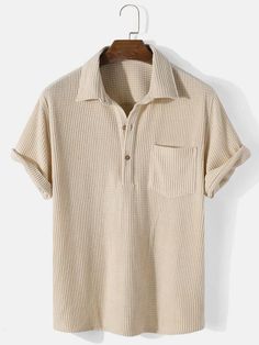 a beige polo shirt hanging on a hanger