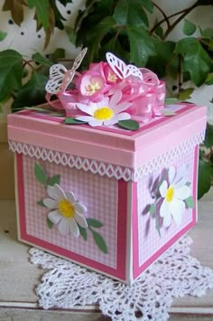 a pink and white box with flowers on the inside is sitting on a lace doily