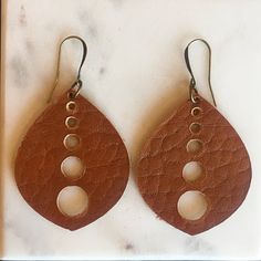 "These simple yet elegant leather earrings are lightweight and so easy to wear. Unique and original designs are hand crafted from Horween leather and are a classic addition to any outfit any time of year. Details: * the teardrop shape is 2.4\" long and 1.425\" wide * antique silver or antique brass ear wire Your order comes wrapped in a simple kraft pillow box perfect for a gift or just to treat yourself!Ear wires are nickel free. Perfect for customers with sensitive skin." Modern Brown Leather Earrings, Handmade Minimalist Leather Earrings, Adjustable Drop Earrings For Everyday Use, Elegant Brown Leather Earrings, Leather Dangle Earrings With Ear Wire, Handmade Leather Earrings For Everyday, Leather Earrings As A Gift, Handmade Leather Everyday Earrings, Everyday Handmade Leather Earrings