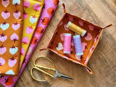 sewing supplies are laid out on a wooden table