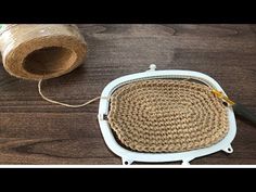 a basket sitting on top of a wooden floor next to a roll of twine