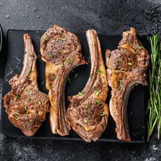 steaks with herbs on a black plate