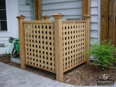 a wooden trellis in front of a house next to a planter and fence