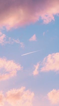 an airplane is flying in the sky with pink clouds