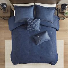 a bed with blue linens and pillows on it