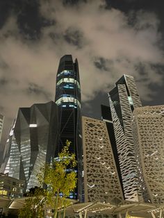 some very tall buildings that are next to each other in the dark sky at night