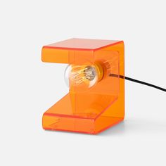 an orange object with a light bulb on it's side and wires attached to it