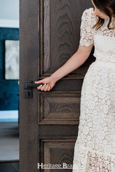 a woman in a white dress is opening the door