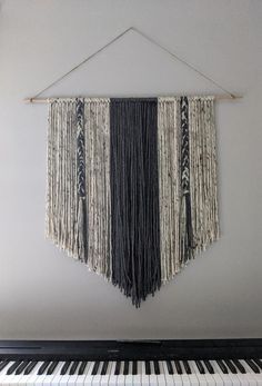 a black and white wall hanging on the side of a piano with strings attached to it