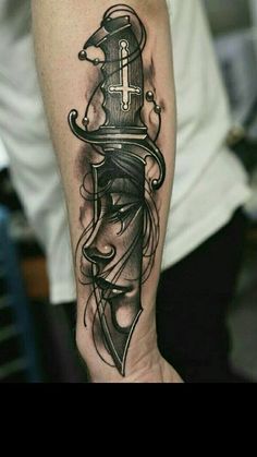 a man's arm with a black and white tattoo design on it, including a dagger