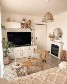 a living room filled with furniture and a flat screen tv mounted on the wall above a fire place