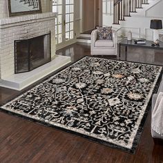 a living room filled with furniture and a rug on top of a hard wood floor