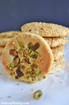 three cookies stacked on top of each other with nuts and pistachios in the middle