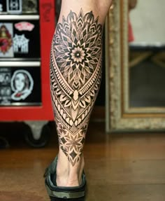 a man's leg with a tattoo on it and an intricate flower in the center