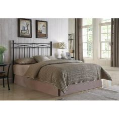 a bedroom with white walls and beige bedding, two framed pictures on the wall