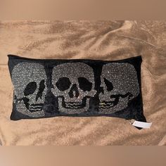 a black and silver pillow with two skulls on it