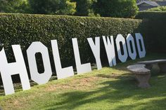 the hollywood sign is displayed in front of a hedged area with a picnic table and bench