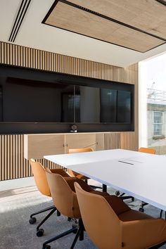 an empty conference room with white table and brown chairs