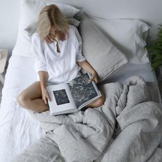 a woman sitting in bed reading a book