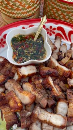 a plate with meat and sauce on it next to two baskets full of other foods