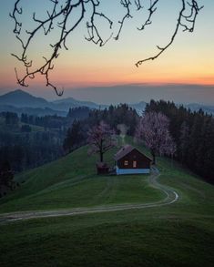 a small cabin sits on top of a grassy hill