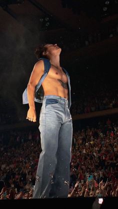 a shirtless man standing on top of a stage