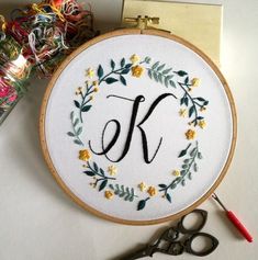 a cross stitch monogram with the letter k in it and scissors next to it