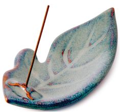 a blue and white leaf shaped dish with a wooden stick sticking out of it's center