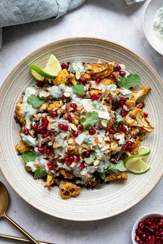 a white plate topped with chicken and pomegranate