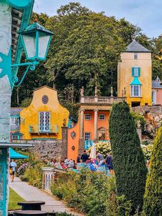 colorful houses and gardens in the middle of a park with lots of greenery on both sides