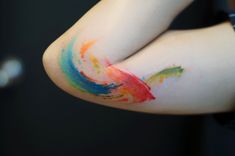 a person's arm with colorful paint on it