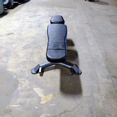 a black office chair sitting on top of a hard wood floor in an industrial building