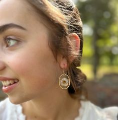 "This listing is for one pair of small white Needle Chrysanthemum resin earrings in small oval shaped frames. These white Needle Chrysanthemum earrings are light weight, hand poured, carefully crafted and uniquely designed! Created with real dried flowers, these earrings are a perfect gift for a friend, girlfriend, wife, fiancé or even for yourself!   -All of our earrings use NICKEL FREE AND LEAD FREE HYPOALLERGENIC HOOKS.   Every earring is hand crafted and so each are unique! CHECK OUT OTHER BEAUTIFUL OPTIONS FROM OUR CHRYSANTHEMUM COLLECTION -Tear dropped shaped Needle Chrysanthemum Earrings: https://www.etsy.com/listing/1485295330 -Heart shaped Needle Chrysanthemum Earrings: https://www.etsy.com/listing/1485270786 -Circle Shaped Needle Chrysanthemum Earrings: https://www.etsy.com/listi Delicate White Teardrop Flower Earrings, Delicate Hypoallergenic Flower Earrings For Everyday Wear, Bohemian Pressed Flowers Drop Earrings, Delicate Teardrop Flower Earrings For Pierced Ears, Gold Pressed Flower Earrings, Delicate Teardrop Flower Earrings, White Earrings With Pressed Flowers, White Pressed Flowers Earrings, Delicate Nickel-free White Earrings