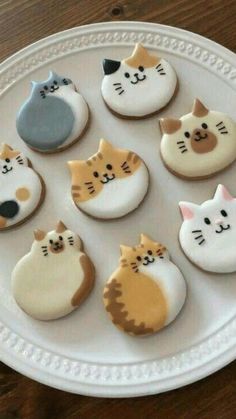 a white plate topped with different types of decorated cookies on top of a wooden table