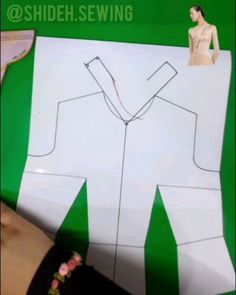 a person is cutting out a shirt with scissors and tape on the back of it