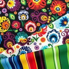 three different types of colorful flowers on black fabric with multi - colored stripes and colors