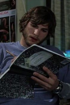 the young man is reading his book in bed