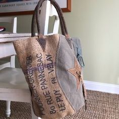 a handbag sitting on top of a white chair next to a table with a book