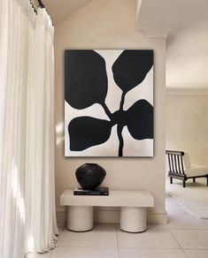 a black and white painting hanging on the wall