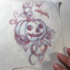 a drawing of a pumpkin with vines and bats on it's face is being held up