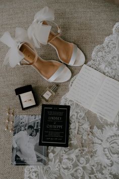 the wedding shoes are on the bed next to the ring box and other items for the bride's dress