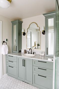 a bathroom with double sinks and green cabinets