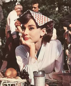 a woman sitting at a table wearing a hat